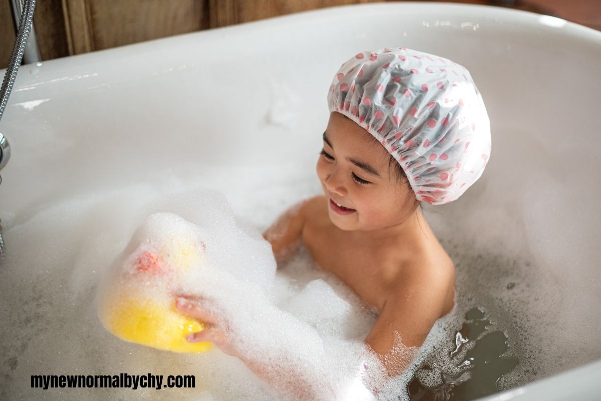 a-child-in-a-bubble-bath-tub-holding-a-yellow-duck-practicing-phonics