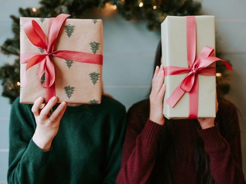 two-women-holding-up-gift-boxes