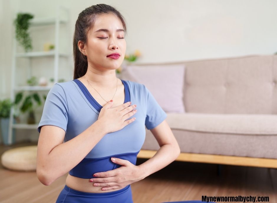 Lady-seated-on-the-floor-with-one-hand-placed-on-her-chest-and-the-other-on-her-belly-she-is-taking-deep-breaths
