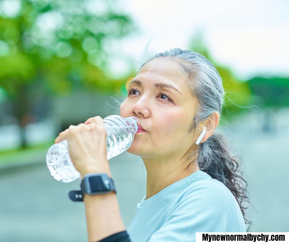 A-middle-aged-woman-drinking-water-from-a-bottle-15-simple-summer-self-care-ideas-for-busy-moms